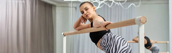 Graceful woman dancing near bar, her sporty attire and toned physique exuding confidence, banner — Stock Photo