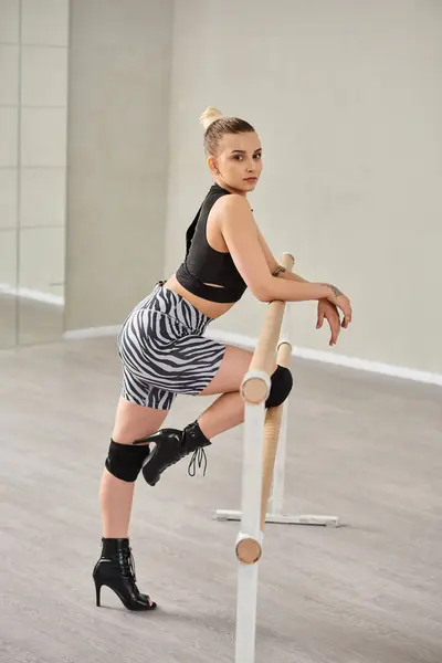 Una bailarina elegante encuentra equilibrio en la barra mientras se inclina con precisión, coreografía perfecta - foto de stock