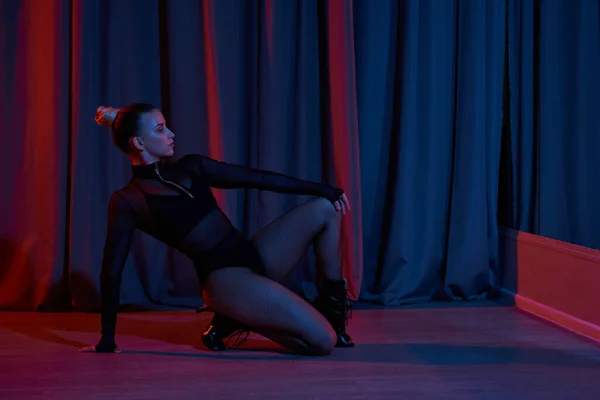 Une femme s'assoit sur le sol, ses pieds dansants revêtus de chaussures, tandis qu'elle se prépare pour la performance sur scène — Photo de stock