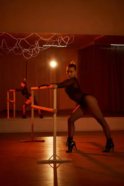 Verführerische Tänzerin im Trikot und Strumpfhosen perfektioniert ihre Choreographie an einer Stange, fließende Bewegungen — Stockfoto