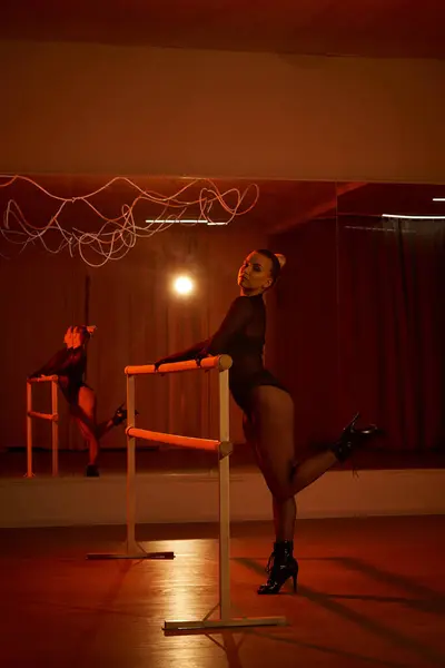 Woman in a leotard and tights perfects her choreography on a bar, fluid movements — Stock Photo