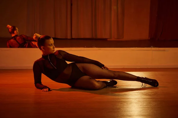 Eine talentierte Person in High Heels posiert anmutig auf der Tanzfläche im Studio, fesselnde Szene — Stockfoto