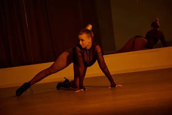 Tänzerin posiert, während sie ihr Gleichgewicht und ihre Fließfähigkeit in einem schwarzen Trikot und High Heels zur Schau stellt — Stockfoto