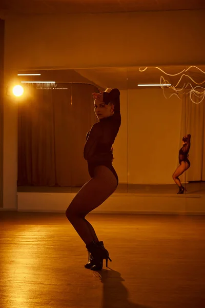Eine Tänzerin in Netzstrumpfhose und schwarzem Trikot tanzt in einem Studio — Stockfoto