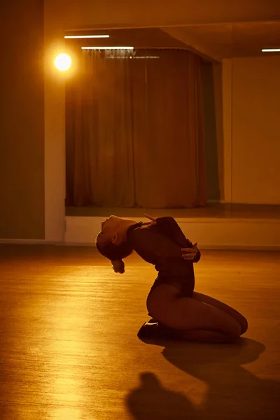 Captivating and mysterious, a woman gracefully moves across the dark floor — Stock Photo