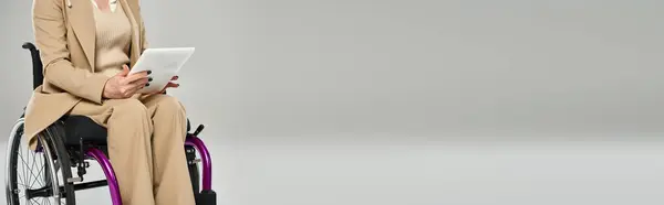 Vista cortada de mulher com deficiência em cadeira de rodas em pastel traje segurando tablet nas mãos, banner — Fotografia de Stock