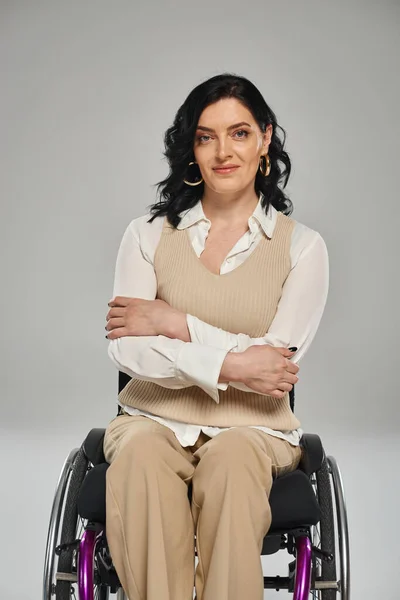 Cheerful good looking confident woman with disability sitting in wheelchair and smiling at camera — Stock Photo