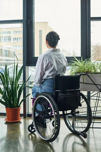 Femme d'affaires dévouée avec un handicap assis dans son fauteuil roulant tout en travaillant dur au bureau — Photo de stock