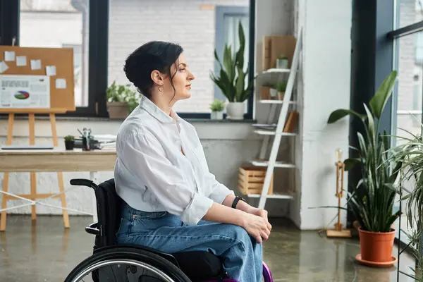 Красивая преданная деловая женщина в элегантном наряде сидит в инвалидном кресле и смотрит в сторону — стоковое фото