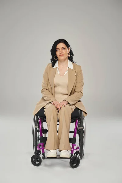 Bella donna disabile in elegante abito pastello in sedia a rotelle guardando dritto alla fotocamera — Foto stock
