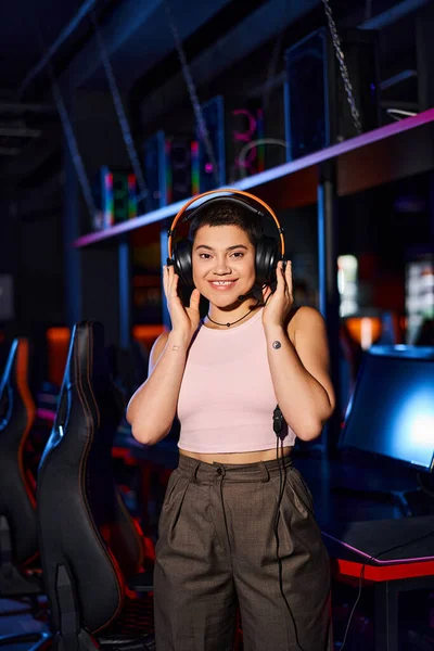 A stylish young woman in indoor setting wearing headphones, immersing herself in music — Stock Photo