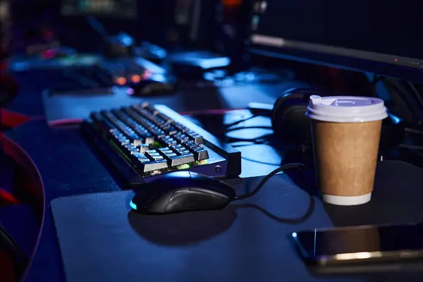 Modern office set-up with a sleek computer keyboard and mouse on a table next to a cup of coffee — Stock Photo