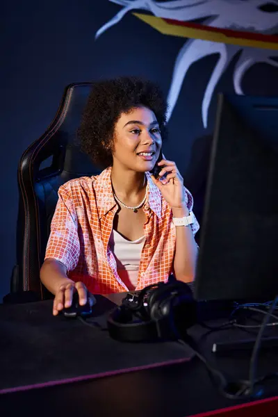 Heureuse femme noire en utilisant l'ordinateur et avoir un appel téléphonique près de l'ordinateur, cybersport et jeux — Photo de stock