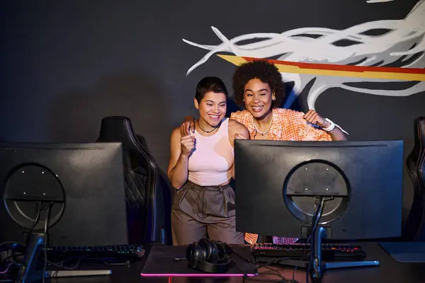 Multicultural and happy friends looking at computer monitor and celebrating victory, cybersport — Stock Photo