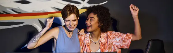 Multicultural happy female friends looking at computer monitor and celebrating victory, banner — Stock Photo