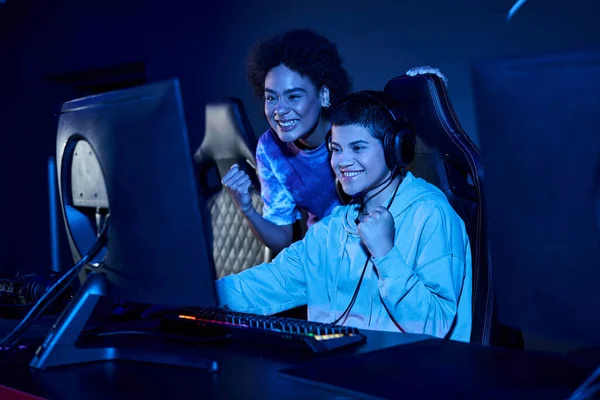 Excitées femmes interraciales concentrées sur une session de jeux cybersport, zoomer âge amies — Photo de stock
