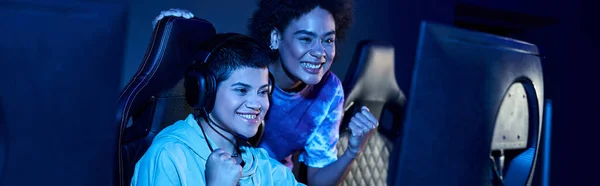 Excitées et jeunes femmes interraciales remportant un match dans une session de jeu cybersport, bannière horizontale — Photo de stock