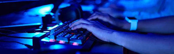 Banner recortado de manos femeninas, jugador joven usando el teclado de la computadora mientras que juega juego, cybersport - foto de stock