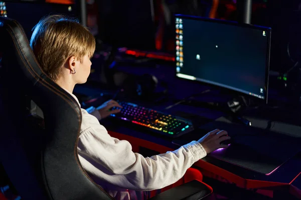 Joueur jouant à des jeux de cybersport sur un ordinateur avec un écran vif, clavier avec éclairage — Photo de stock