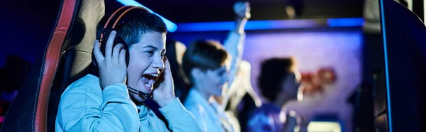 Focus on cheerful young woman winning game next to diverse female friends, cybersport gamers banner — Stock Photo