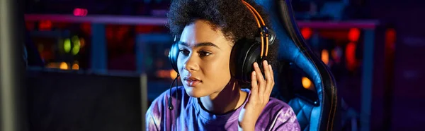 Gamer afro-américain dans les écouteurs regardant le moniteur jouer au jeu d'ordinateur, bannière cybersport — Photo de stock
