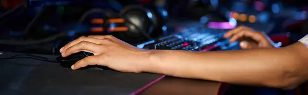 Обрізаний знімок жінки за допомогою комп'ютерної миші біля освітленої клавіатури під час гри, банер — стокове фото
