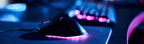 Крупним планом освітлена комп'ютерна миша біля комп'ютерної клавіатури, банер ігрових аксесуарів — стокове фото