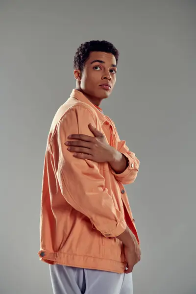 Schöner Mann im pfirsichfarbenen Hemd steht vor grauer Wand, Modebewusstsein zeigt seine Persönlichkeit — Stockfoto