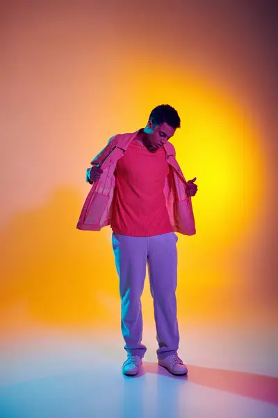 Стильний афроамериканський чоловік позує в модному і повсякденному одязі з яскравим градієнтним фоном — стокове фото