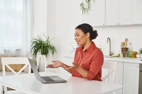 Nutricionista feminina alegre fornecendo consulta on-line enquanto trabalhava remotamente de sua cozinha — Fotografia de Stock