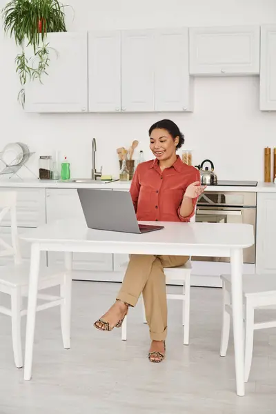 Счастливая женщина диетолог предоставление онлайн консультации во время работы удаленно от ее кухни — стоковое фото