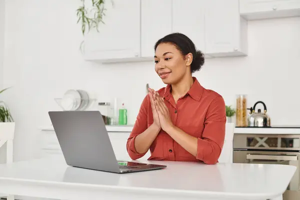 Sorridente nutrizionista femminile che fornisce consulenza online mentre lavora a distanza dalla sua cucina — Foto stock