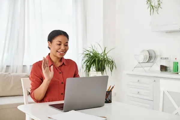 Happy african american nutritionist providing online consultation on laptop from her kitchen — Stock Photo