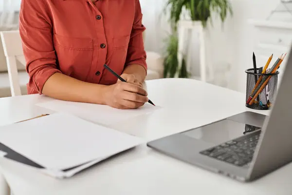 Cropped view of nutritionist taking notes during online consultation on laptop on desk — Stock Photo
