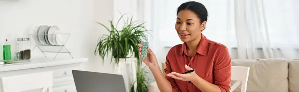 Smiling female dietitian showing medication during an online consultation on laptop, banner — Stock Photo