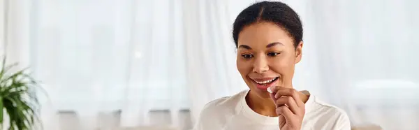 Banner of happy african american woman taking pill at home, perfect for health and wellness — Stock Photo