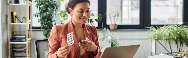 Happy african american nutritionist recommending supplements during online consultation from office — Stock Photo