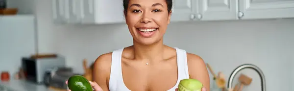 Pancarta de mujer afroamericana con cinta métrica y frutas promoviendo una dieta saludable en la cocina - foto de stock