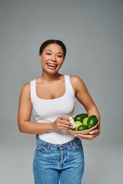 Nutricionista afro-americano alegre com frutas verdes e suplementos que mostram estilo de vida saudável — Fotografia de Stock