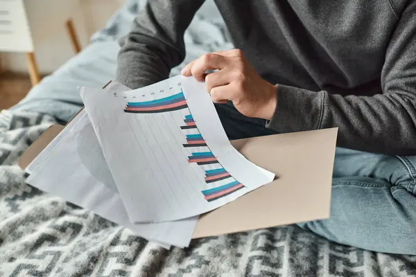 Cropped photo of man analyzing graphs while sitting in bedroom, productive work from home — Stock Photo