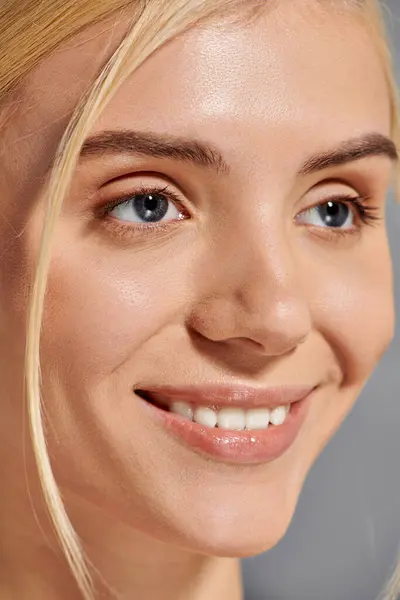 Nahaufnahme eines schönen Mädchens mit breitem Lächeln und gesunden Zähnen im grauen Hintergrund — Stockfoto