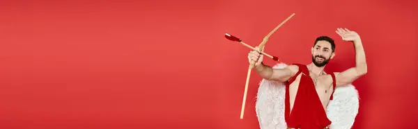 Uomo cupido sorridente arciere con freccia a forma di cuore sul rosso, giorno st San Valentino, banner orizzontale — Foto stock
