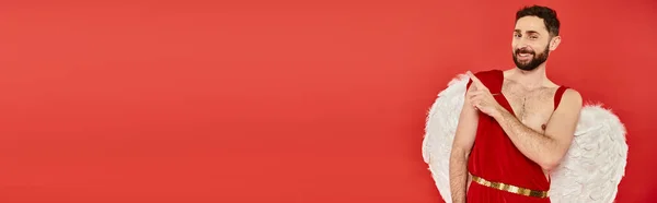Drôle homme cupide barbu regardant la caméra et pointant du doigt sur rouge, bannière horizontale — Photo de stock