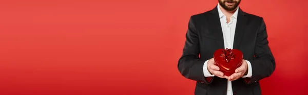 Cropped view of wealthy elegant man with st valentines day present in heart-shaped gift box, banner — Stock Photo