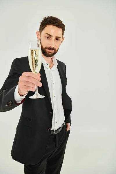 Joyful elegant bearded man toasting with champagne on Saint Valentines day and looking at camera — Stock Photo