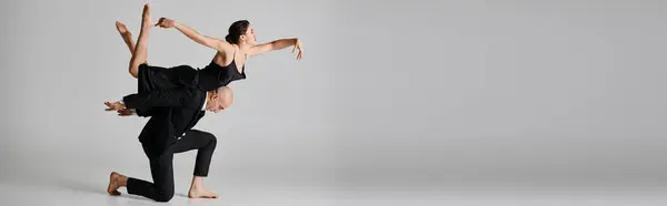 Graciosa dança, jovem casal realizando uma rotina acrobática em estúdio em cinza, banner — Fotografia de Stock