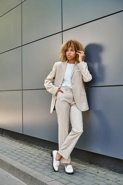 Кучерява афроамериканська бізнес-леді в офісному одязі позує біля офісної будівлі, молодий лідер — стокове фото