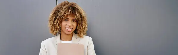 Positive jeune femme d'affaires afro-américaine en tenue formelle dossier par mur de bureau, bannière — Photo de stock