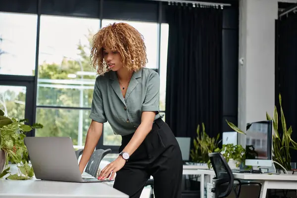 Envolvido no trabalho jovem afro-americano profissional usando laptop em uma mesa de escritório bem iluminada — Fotografia de Stock