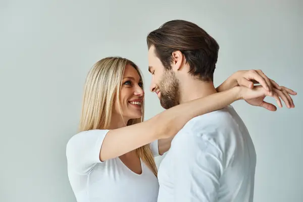 Un uomo e una donna si abbracciano appassionatamente, esibendo amore e intimità in modo sensuale. — Foto stock